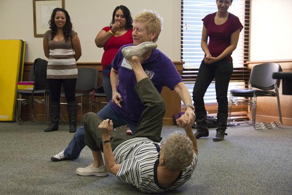 Midge Marino and Patty Woodward demonstrate how to use the arch of her right foot to kick straight into the face of an attacker during the Trade Your Fear For Anger workshop.
