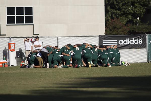 The men’s soccer team huddling before the game against UC Davis.
