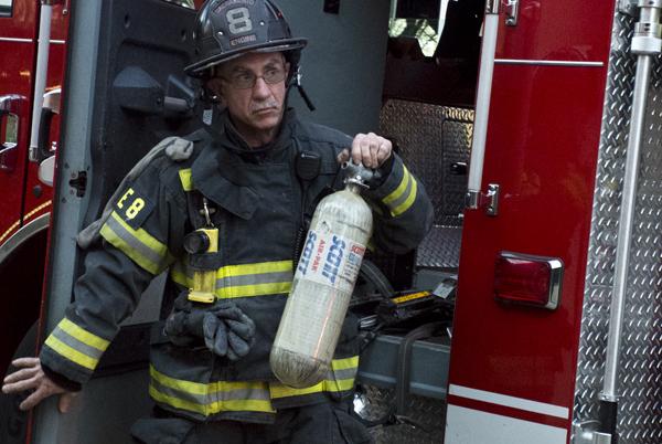 A Sacramento Engine 8 firefighter readies an air tank after the events caused by a lab oven at Alpine Hall Wednesday afternoon.
