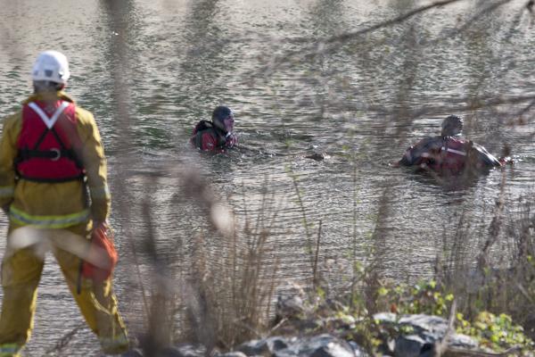 Divers extract the body found in the American River on Tuesday morning. Scott Morse, spokesperson for the Sacramento City Police, said the body will be identified by the coroners office.
