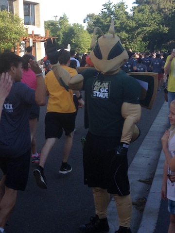 Herky giving out high fives to the runners. 
