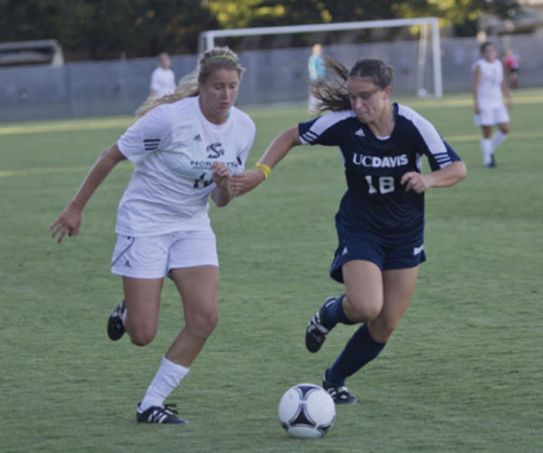 Sac State forward, No. 16, Kassidy Kellogg runs the ball past a UC Davis defender, but her effort was not enough for the Hornets on Friday. 