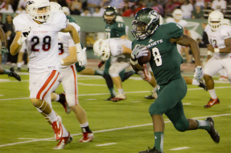 Sac State Hornet running back Ezekiel Graham No. 8 runs through Southern Oregon’s defense for a first down on Saturday night.