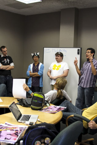 Members listen as the club's president and Sacramento State art major Carlos Alfaro, 20, talks about the meeting's agenda.
