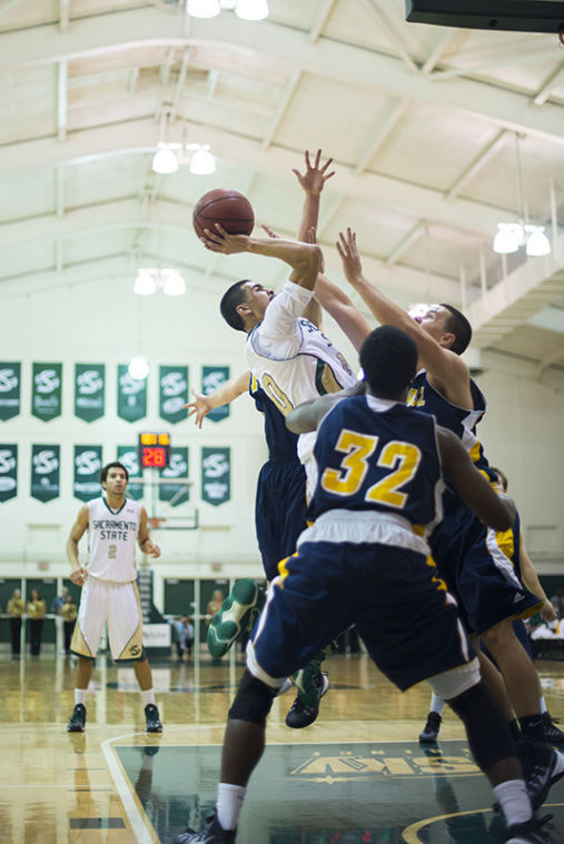 Junior guard No. 10 Mikh McKinneys shot is contested by the UC Santa Cruz Banana Slug defenders.