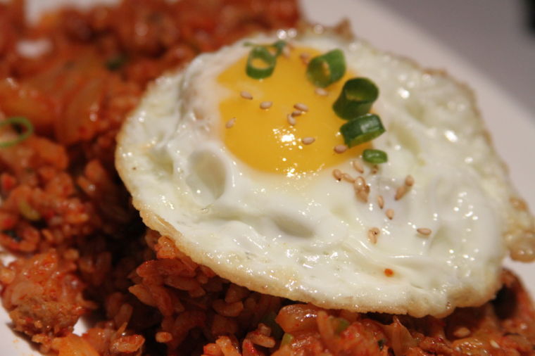 Kimchee grid rice comes topped with a sunny-side up fried egg, allowing the runny yolk and the perfectly cooked egg white to act as a sauce and enhance the flavors of the rice. We all grunt our approval.