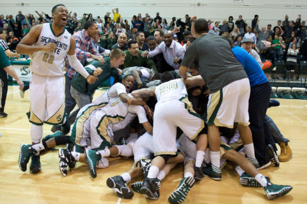 Sacramento State junior point guard Dylan Garrity gets dog-piled by his teammates after he hits a game-winning shot against Weber State