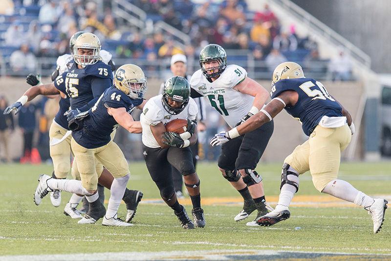 Junior running back De'Jon Coleman runs through UC Davis' defensive line as he picked up a couple of yards against the Aggies. The Hornets defeated their rivals 41-30 in the 61st matchup between the two teams on Saturday, Nov. 22 at UC Davis.