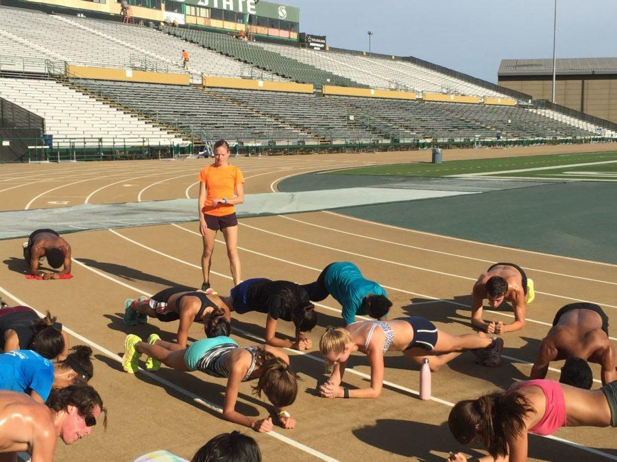 Cross country coach Laura Harmon watches her runners as they stretch out following practice Friday, Aug. 28, 2015 at Hornet Stadium.