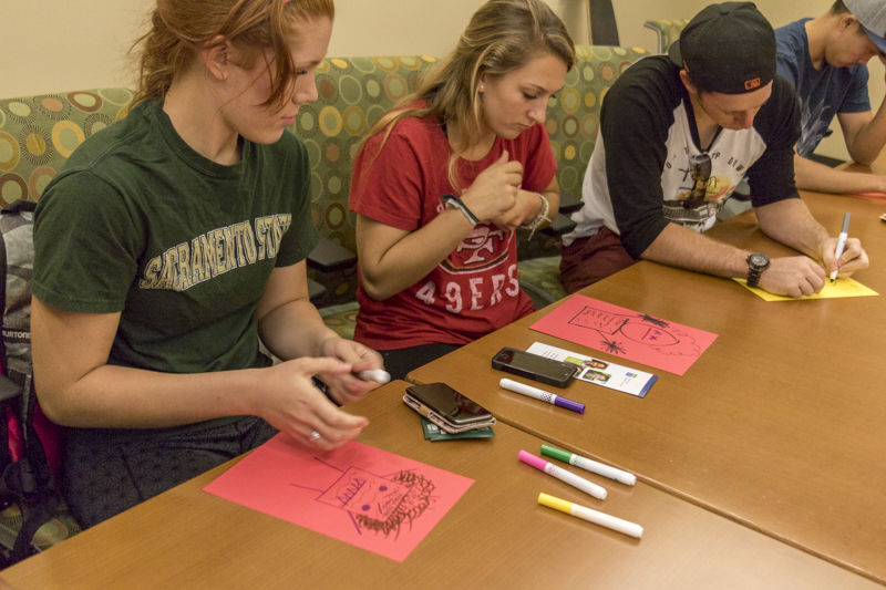 (Left to right) Jaden Garrett, Alexis Taber, and Chad Riley draw a physical embodiment of what their stress looks like in The Well on Tuesday, Oct. 20, 2015.