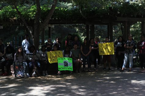 Students gathered at Thursday's demonstration hold signs in support of the Black Lives Matter movement and referencing the issues facing the Black community. 