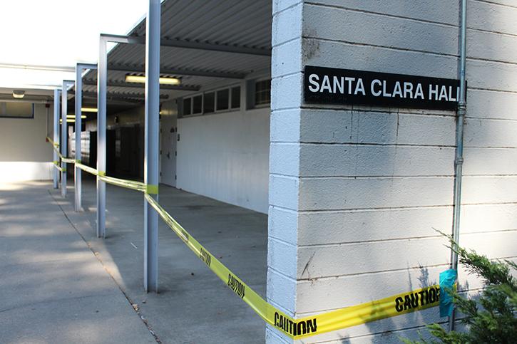 Caution tape surrounds Santa Clara Hall as abatement specialists work to remove lead dust from the building on Sunday, Aug. 28. While cleanup inside the building was nearing completion at the start of the semester, tests revealed additional contamination in the area outside the building. (Photo by Barbara Harvey)