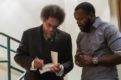 Cornel West signs a copy of his book "Race Matters" for graduate student Antoine Johnson during West's visit to Sacramento State on Thursday, Sept. 29. “He’s one of the remaining writers that I look up to,” Johnson later said. (Photo by Francisco Medina)