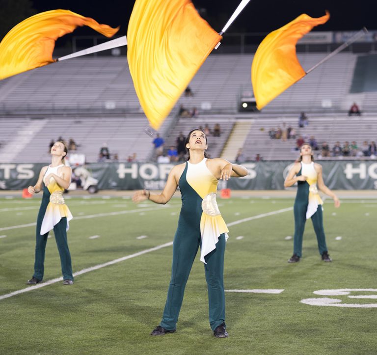 Sacramento State color guard members toss flags in the air during halftime at the homecoming football game at Hornet Stadium on Saturday, Oct. 8.