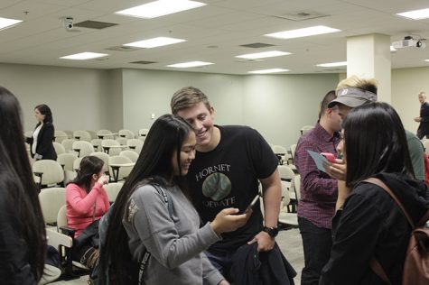 Hornet Debate Team assistant coach Adam Austin, center, looks at a selfie a student just took with him at the Voter Education Forum on Thursday, Oct. 12. To prove they attended the Forum, students were told by their professors to find Austin and take a selfie with him. (Photo by Joel Boland)