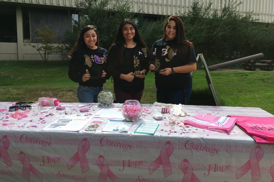 Sisters of Sigma Theta Psi stand behind a table to fundraise for breast cancer awareness outside the LIbrary on Oct. 13.
(Photo by Brian Ingebretsen)