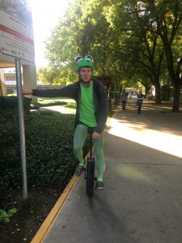 Aiden McIntyre as Kermit the Frog on a unicycle