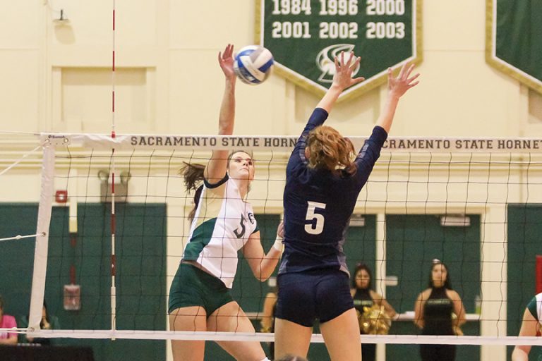 Sacramento State senior outside hitter Madeline Cannon spikes the ball past Lauren Jacobsen of Northern Arizona at the Hornets Nest on Oct. 27. (Photo by Matthew Dyer)