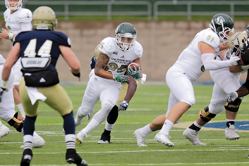 Sacramento State senior running back Jordan Robinson finds a hole to run threw against UC Davis at Aggie Stadium on Saturday, Nov. 19. (Photo by Matthew Dyer)