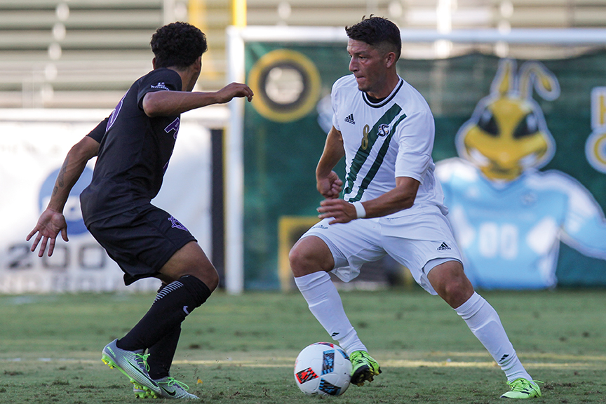 Sacramento State senior midfielder Ivan Ramirez dribbles the ball past a Portland defender at Hornet Field on Sept. 15. (Photo by Matthew Dyer)