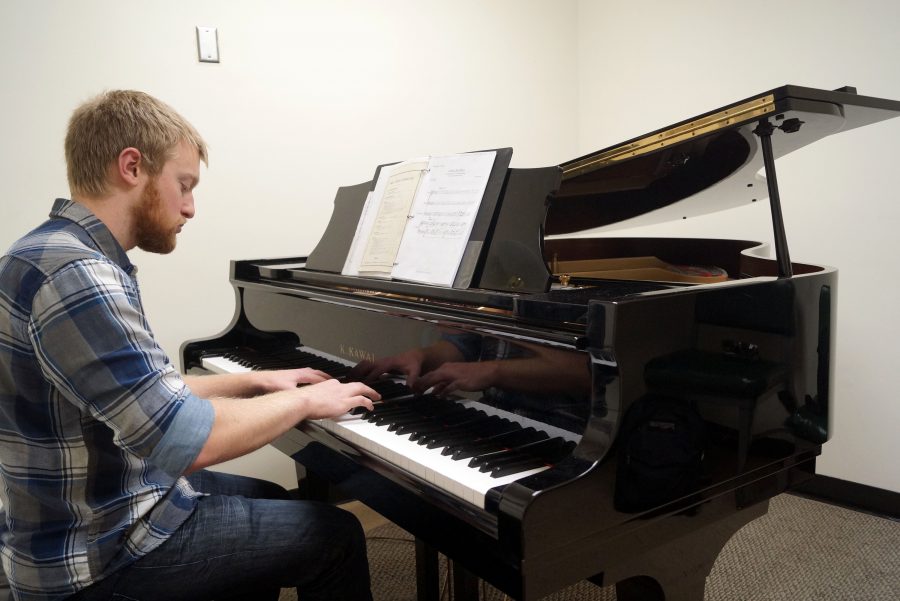 Junior music major Paul Towber, 23, rehearses his composition ‘A Red, Red Rose,’ which is inspired by a poem of Robert Burns. Towber will be conducting his piece at the Music of Heaven and Earth concert on Nov. 5 at the Sacred Heart Church. (Photo by Marivel Guzman)