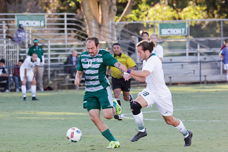 Sacramento State senior forward Nate Nugen fights off a Utah Valley defender at Hornet Field on Sept. 22. (Photo by Matthew Dyer)