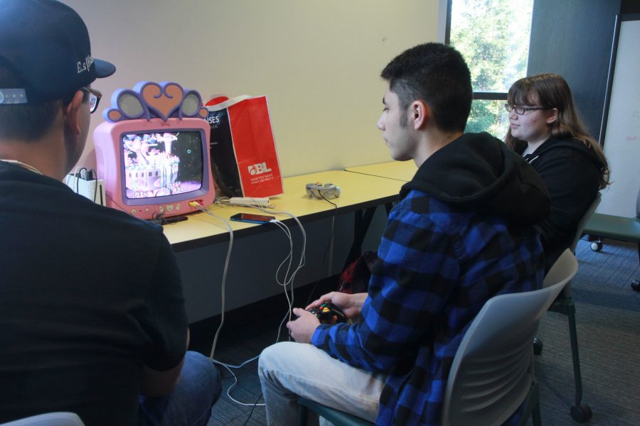 Members Allan Bona, left, and Alex Blanco, right, play the Super Smash Bros. Melee game on their pink TV on the third floor of the AIRC, Thursday, Nov. 3.
(Photo by Harold Williams Jr.)