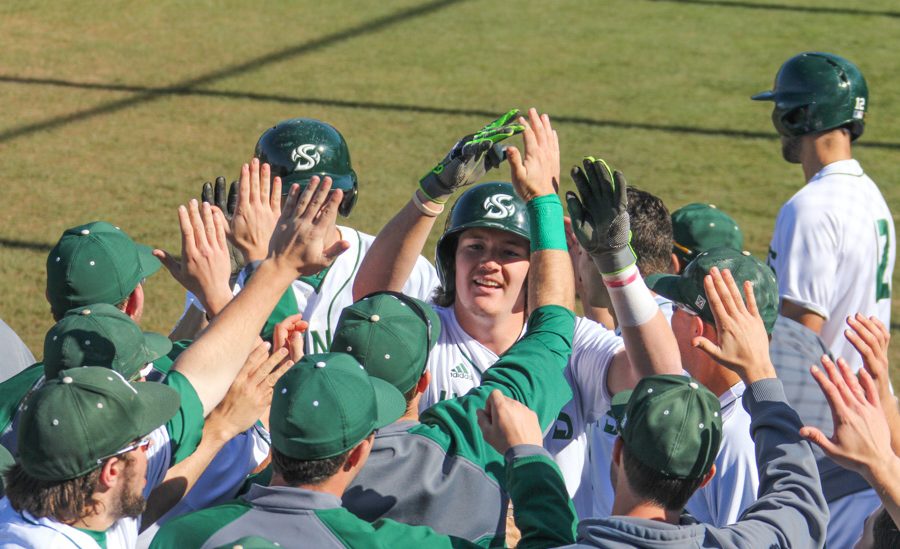 Sacramento State sophomore James Outman celebrates with teammates after scoring a run against Northern Kentucky at John Smith Field on Feb. 26. (Photo by Cameron Leng)