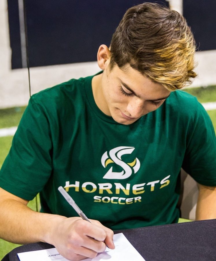 Ivan+Oseguera+signs+his+National+Letter+of+Intent+to+play+soccer+at+Sacramento+State+Feb+1.+%28Photo+courtesy+of+Brent+Robken%29