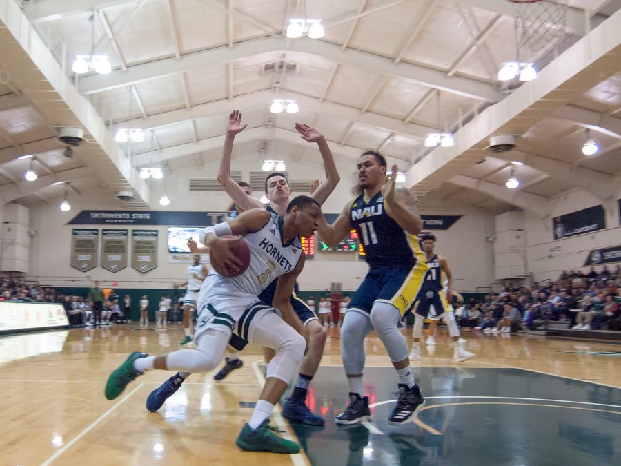 Sacramento State junior forward Justin Strings drives to the paint against two Northern Arizona players at the Nest on Thursday. (Photo by Andro Palting)