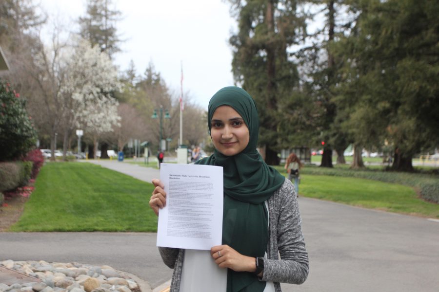 Aya Khalifeh, the president of Students for Justice in Palestine, holds a copy of SJPs divestment resolution, which calls for the CSU to let contracts with certain corporations expire. (Photo by John Ferrannini)
