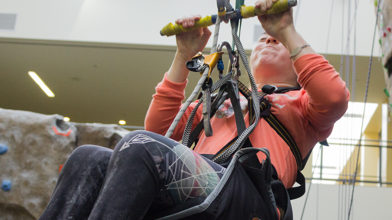 Sacramento State student Olivia Kite uses a pulley system to help her climb up the rock walls at The WELL. (Photo by Rin Carbin)