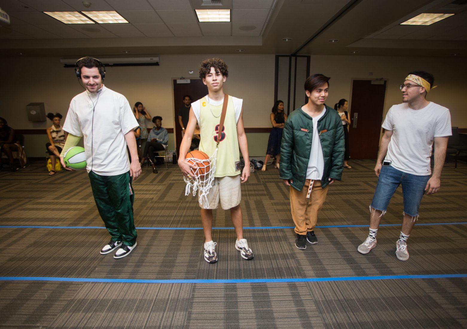 Menswear designer Jose Avila, far right, stands next to his models during rehearsal in the University Union Foothill Suite on Wednesday. (Photo by Nicole Fowler)