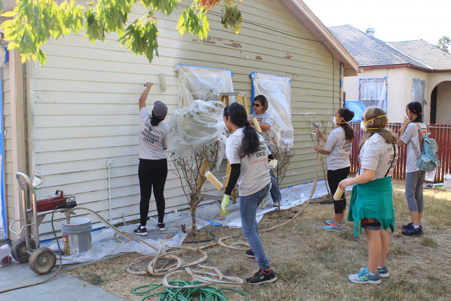 Sacramento State students from the Community Engagement Center paint houses at the 20th annual Paint The Town event in Del Paso Heights Saturday.