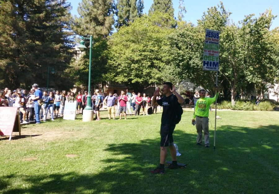 Sacramento State engineering major Slavik Chiley, far right, talks about his religious views in front of a crowd in the Library Quad on Sept. 27.