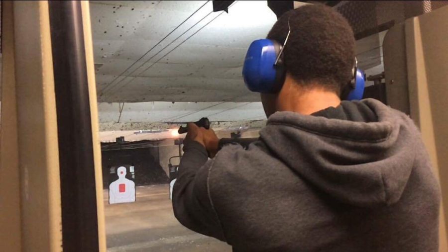 Floyd Johnson II aims for a target at an outdoor gun range in Sacramento