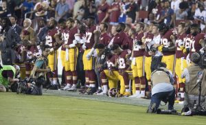The Washington Redskins kneel during the national anthem before a game against the Oakland Raiders.