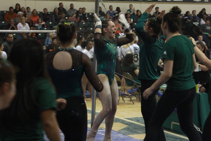 Sacramento State senior gymnast Annie Juarez, middle, celebrates after performing her uneven bars routine at the Nest on Friday, March 16, 2018. Juarez scored a 9.775 in the event and recorded a career-high 39.275 in all four events as an all-arounder on senior night.
