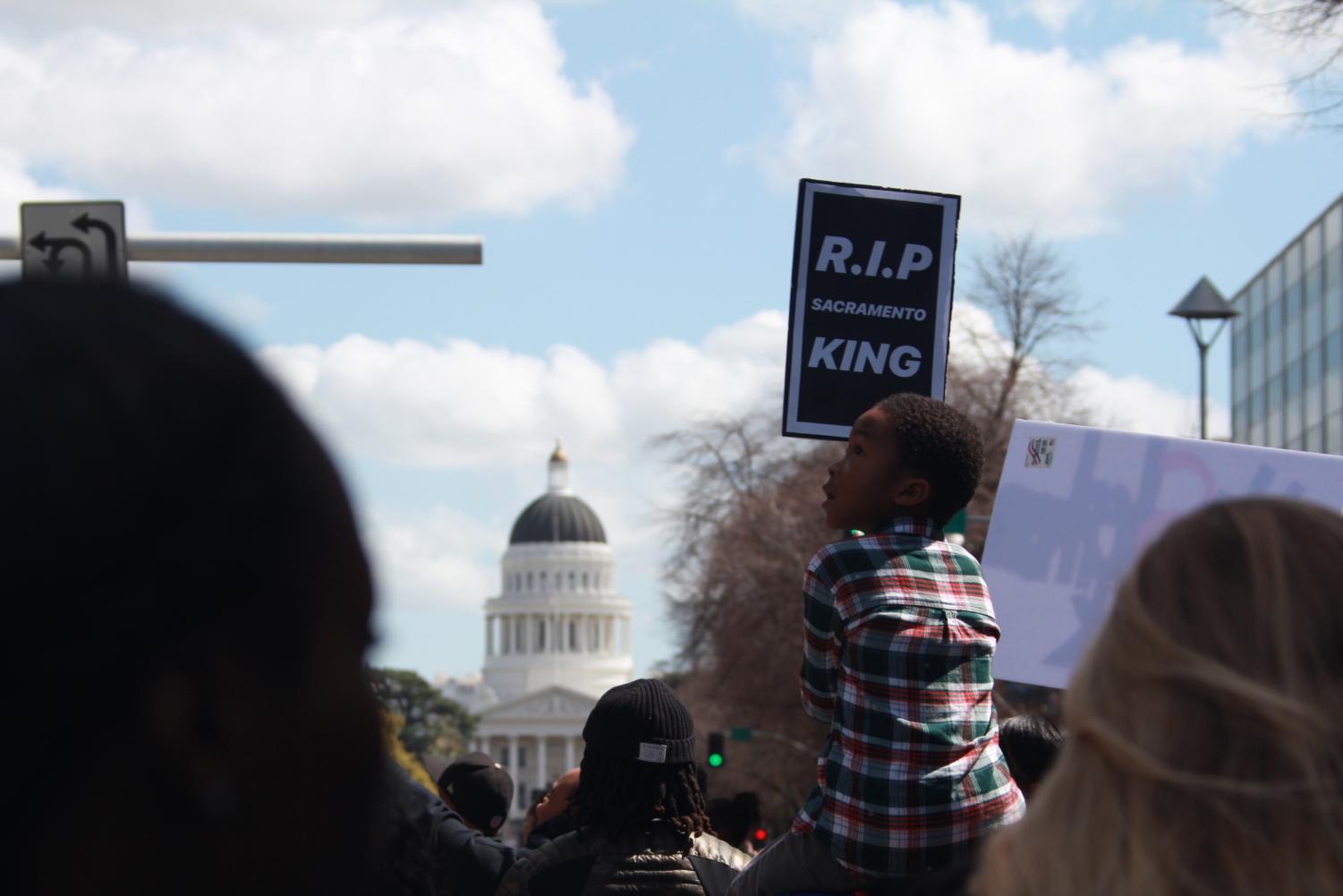 Five-year-old Elias Taylor sits upon his mother Teriah Taylor's shoulders as he holds a sign in a demonstration that took place around downtown Sacramento on Friday, March 23, 2018. Teriah said that she attended the march and brought her son to the demonstration, held in response to the shooting of Stephon Clark by Sacramento Police, because.