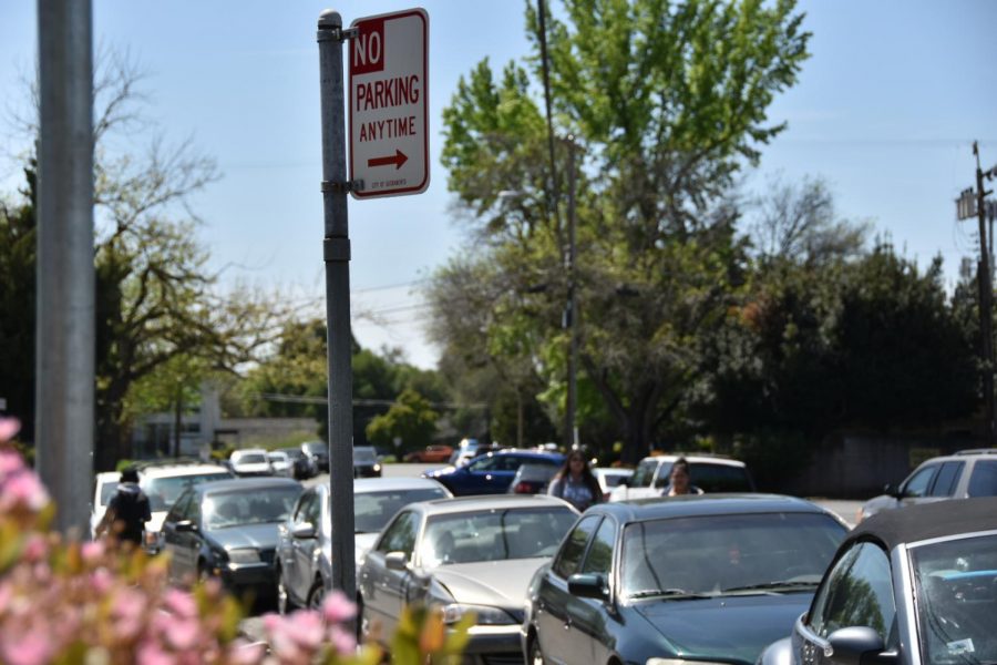A ‘No Parking’ sign on Newman Court flanked by parked cars. Parking is legal anywhere behind the sign unless otherwise marked for emergency fire response or loading zones.