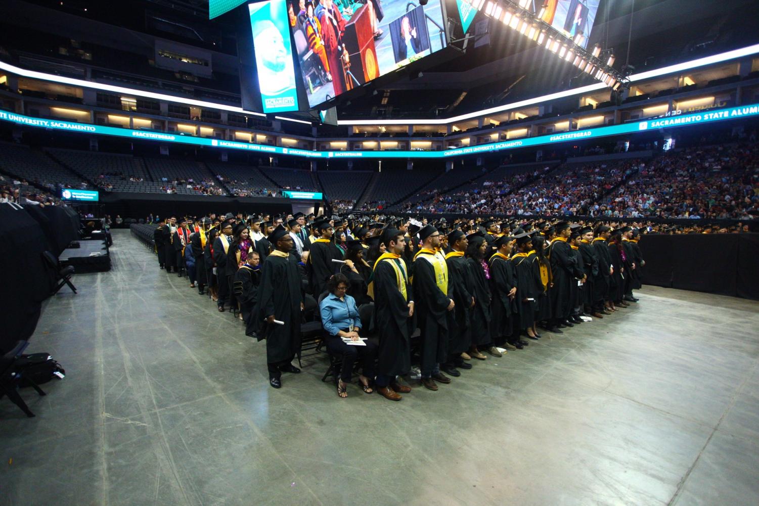 Graduating seniors rise at the Spring 2017 commencement exercises held at Golden 1 Center in downtown Sacramento. Students who wish to have their chosen name read and projected on-screen at the ceremony have to inform Cely Smart, the president's chief communications officer, by April 25 via email.