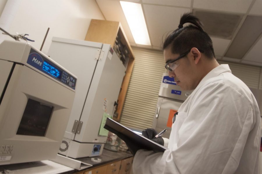 Biochemistry major Kevin Tran uses the microwave in a laboratory on the fifth floor of Sequoia Hall on April 19, 2018 to break down molecules. Tran is working with professor Katherine McReynolds on a project that may yield a topical medicine aimed at preventing the spread of HIV. 