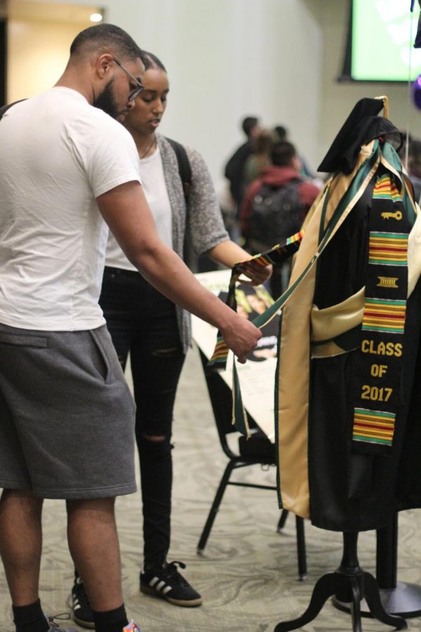 Seniors Tender Cooksie, left, and Yosan Zeweldi look at sashes to wear for graduation at Grad Fest on March 28, 2018.