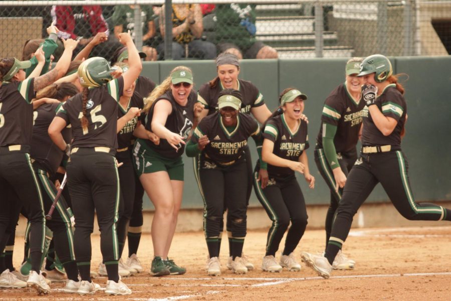 The Sacramento State softball team celebrates with sophomore outfielder Suzy Brookshire, right, after she hit a home run against the University of North Dakota at Shea Stadium on Saturday, April 28, 2018. The Hornets defeated North Dakota 4-1.