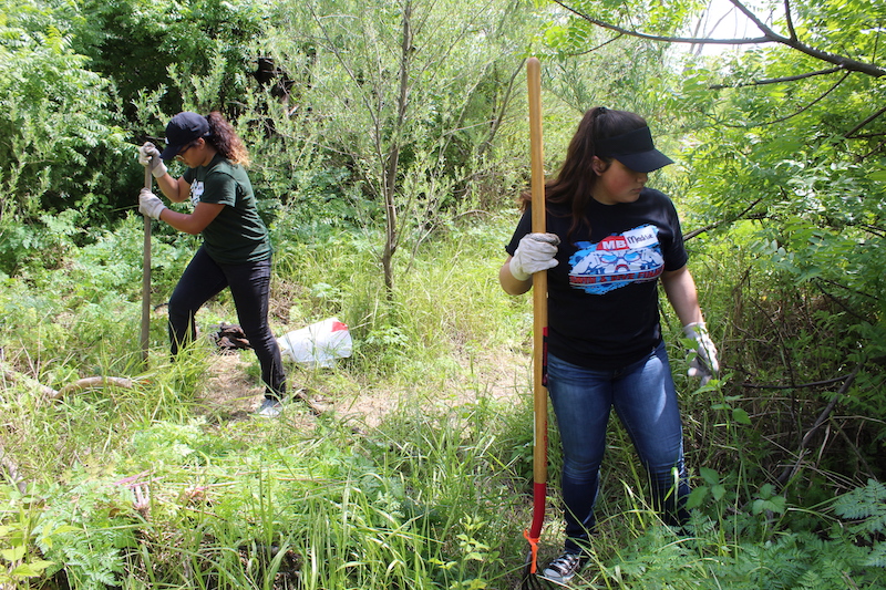 Sacramento State roommates Sarai Bustos (left) and Maddie Hiura work together on helping to restore the pathway to Bushy Lake on Earth Day, April 22, 2018. 