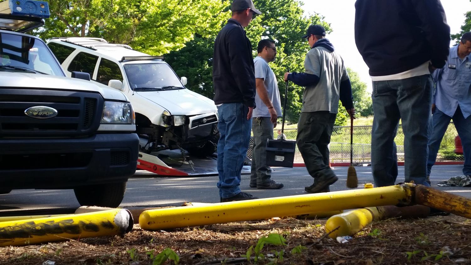A facilities management crew stands in front a pile of damaged guard rails after a driver collided with them and a fire hydrant on Thursday morning. The driver was arrested for driving under the influence according to Sgt. Jeff Reinl of Sacramento State Police.