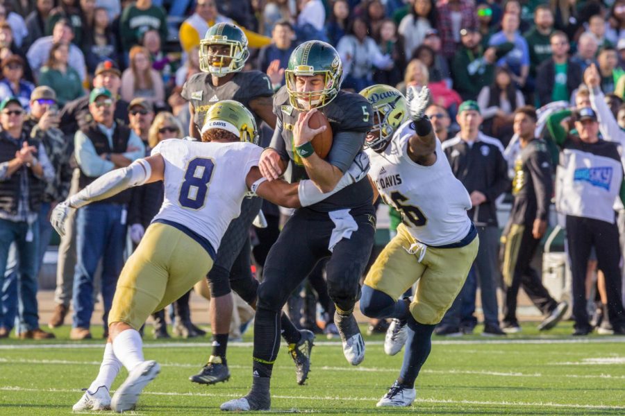 Sacramento State junior quarterback Kevin Thomson, middle, is tackled down by two UC Davis defenders in the 64th annual Causeway Classic at Hornet Stadium on Saturday, Nov. 18, 2017. Sac State defeated the Aggies 52-47. 