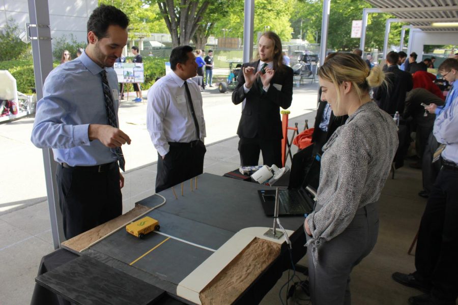 Marco Bonanni (left) and Lauren Rice (right) show how the camera tracks cars through the camera and on to the computer display with their mini-model at the Senior Design Showcase on May 11 in the Santa Clara Hall Breezeway at Sacramento State.