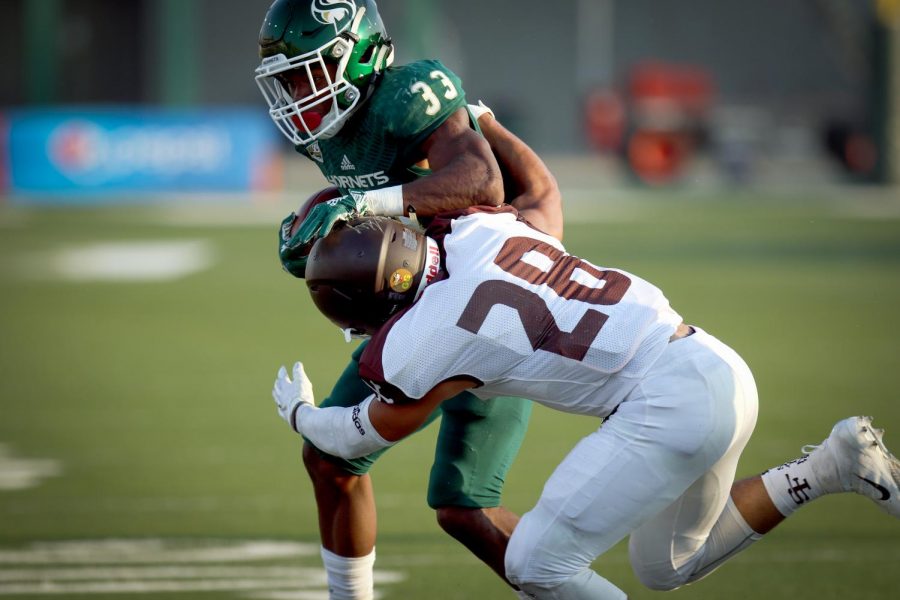 Sacramento State sophomore running back Elijah Dotson is tackled by Rio Strama of University of St. Francis (IL) during the Hornets first home game of the season on Sept. 1, 2018.