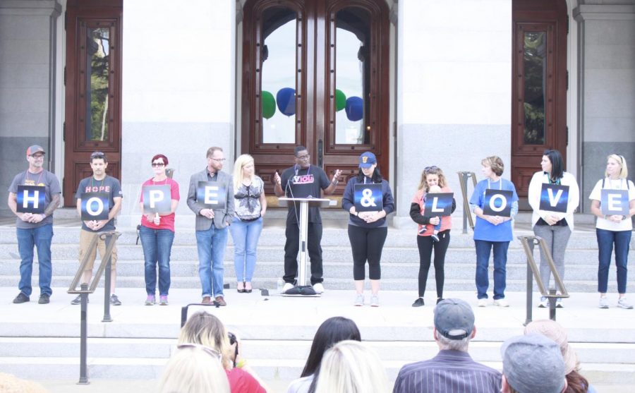 Radio host Big Al Sams standing with participants of the Sacramento Out of The Darkness Walk on the west steps of the California State Capitol Building Saturday, Sept. 29, 2018. The participants holding signs that spell out HOPE & LOVE each represented a color of bead necklaces handed out at the event that signified a family member, friend, loved one or themselves that have considered or died from suicide.